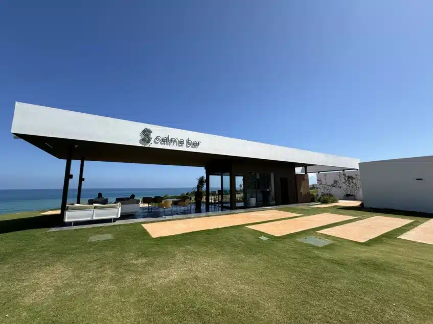 Vista exterior de "Calma Bar", la moderna Halfway House de La Hacienda Golf Resort, con un diseño minimalista y vistas al mar Mediterráneo. Un espacio de descanso para golfistas con una arquitectura innovadora y sostenible.